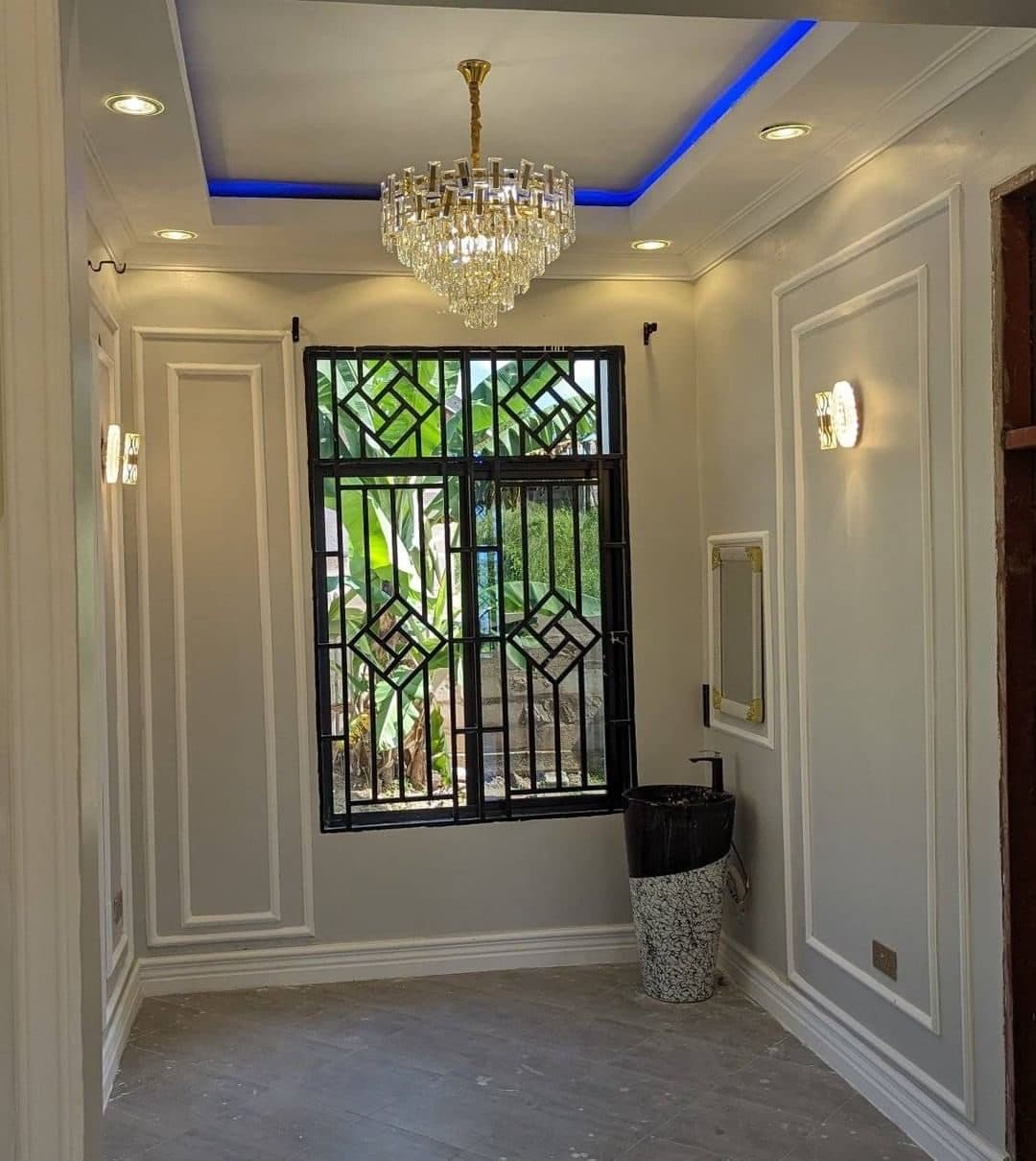 Classical wall panelling and crystal chandelier against fretwork window grilles - bespoke joinery by Royalwoods Interiors, Nairobi