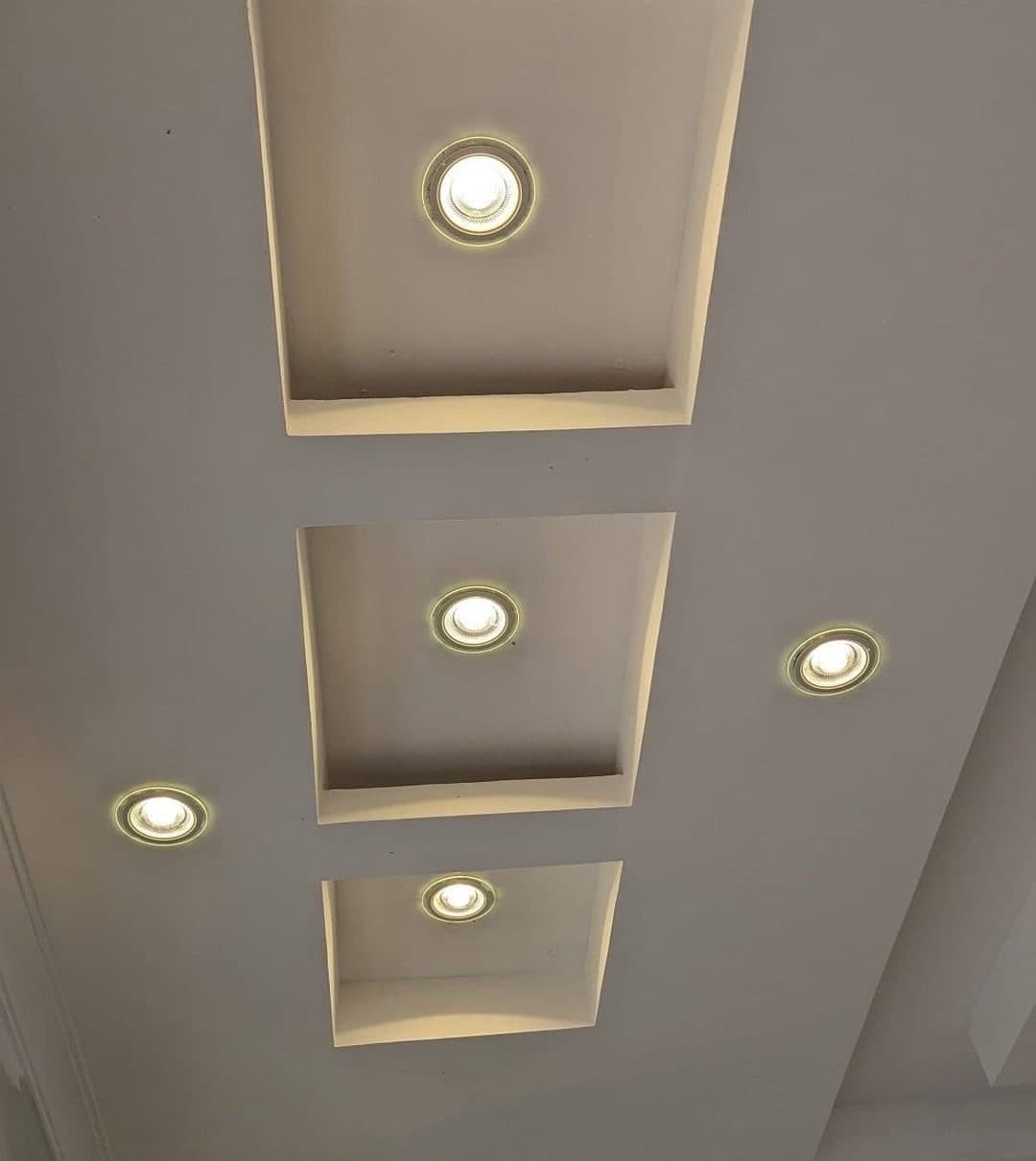 Stepped gypsum ceiling recesses with warm recessed lighting - bespoke joinery by Royalwoods Interiors, Nairobi