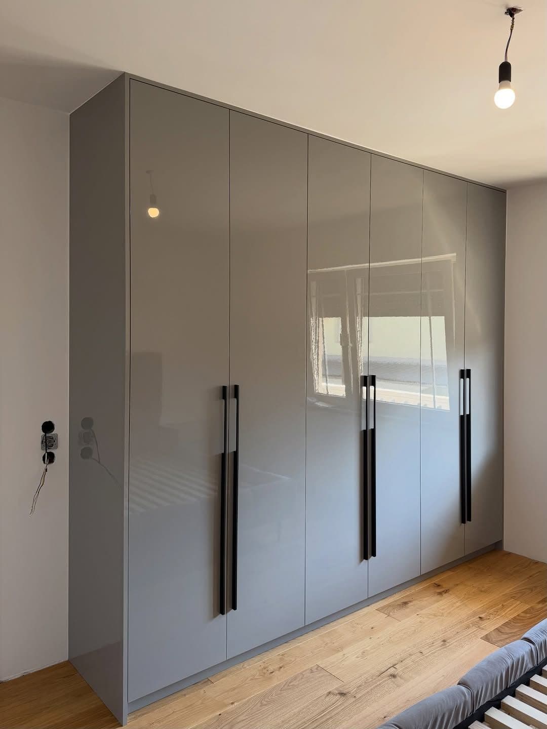 High-gloss push-open wardrobe with slim black pull rails in a master bedroom - bespoke joinery by Royalwoods Interiors, Nairobi