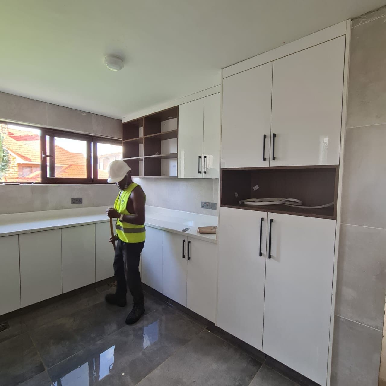 Final inspection pass on wall and base cabinets before handover prep - bespoke joinery by Royalwoods Interiors, Nairobi