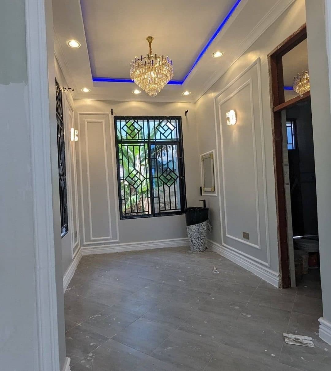 Panelled reception room beneath an LED cove ceiling and chandelier - bespoke joinery by Royalwoods Interiors, Nairobi