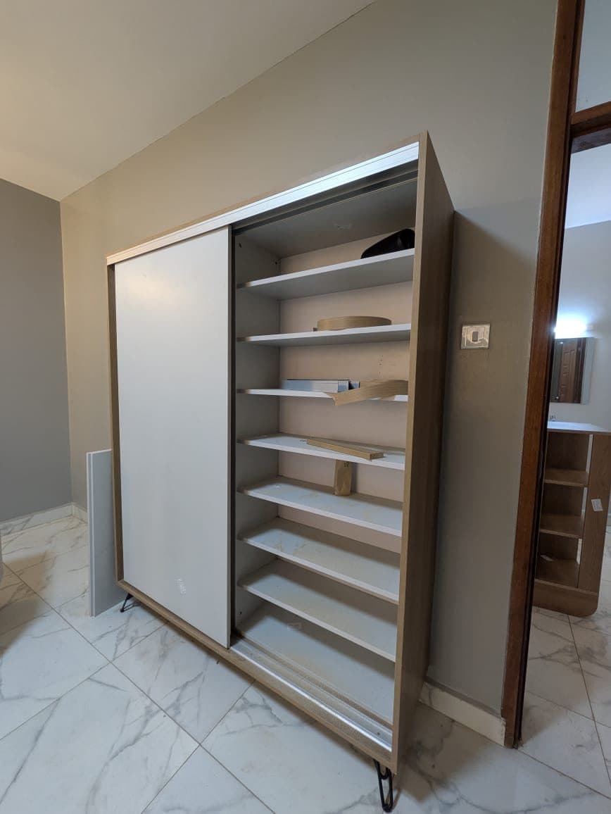 Angled view of the sliding shoe cabinet and its adjustable shelf bank - bespoke joinery by Royalwoods Interiors, Nairobi