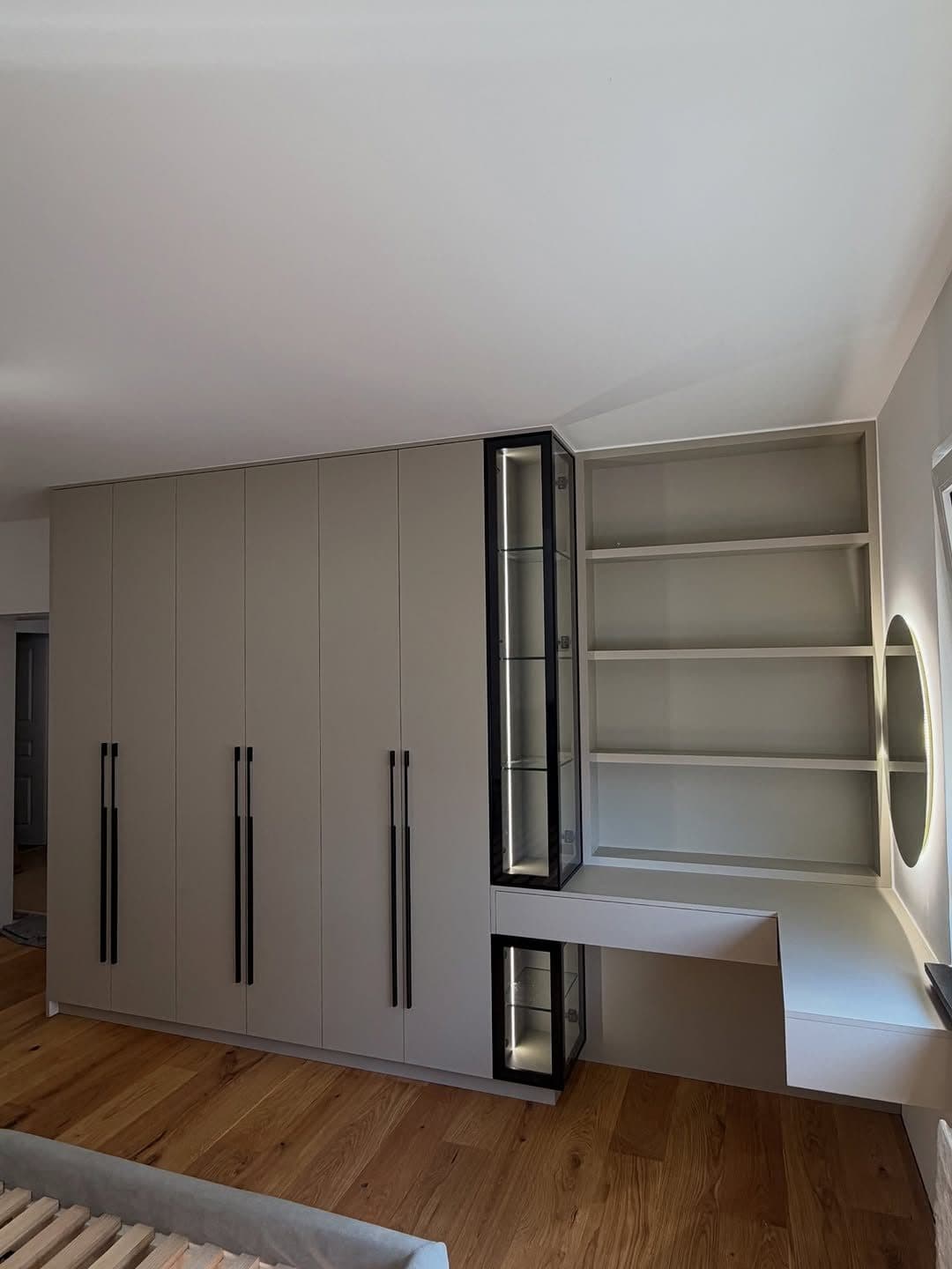 Fitted wardrobe run flowing into a lit glass display case and dressing nook - bespoke joinery by Royalwoods Interiors, Nairobi