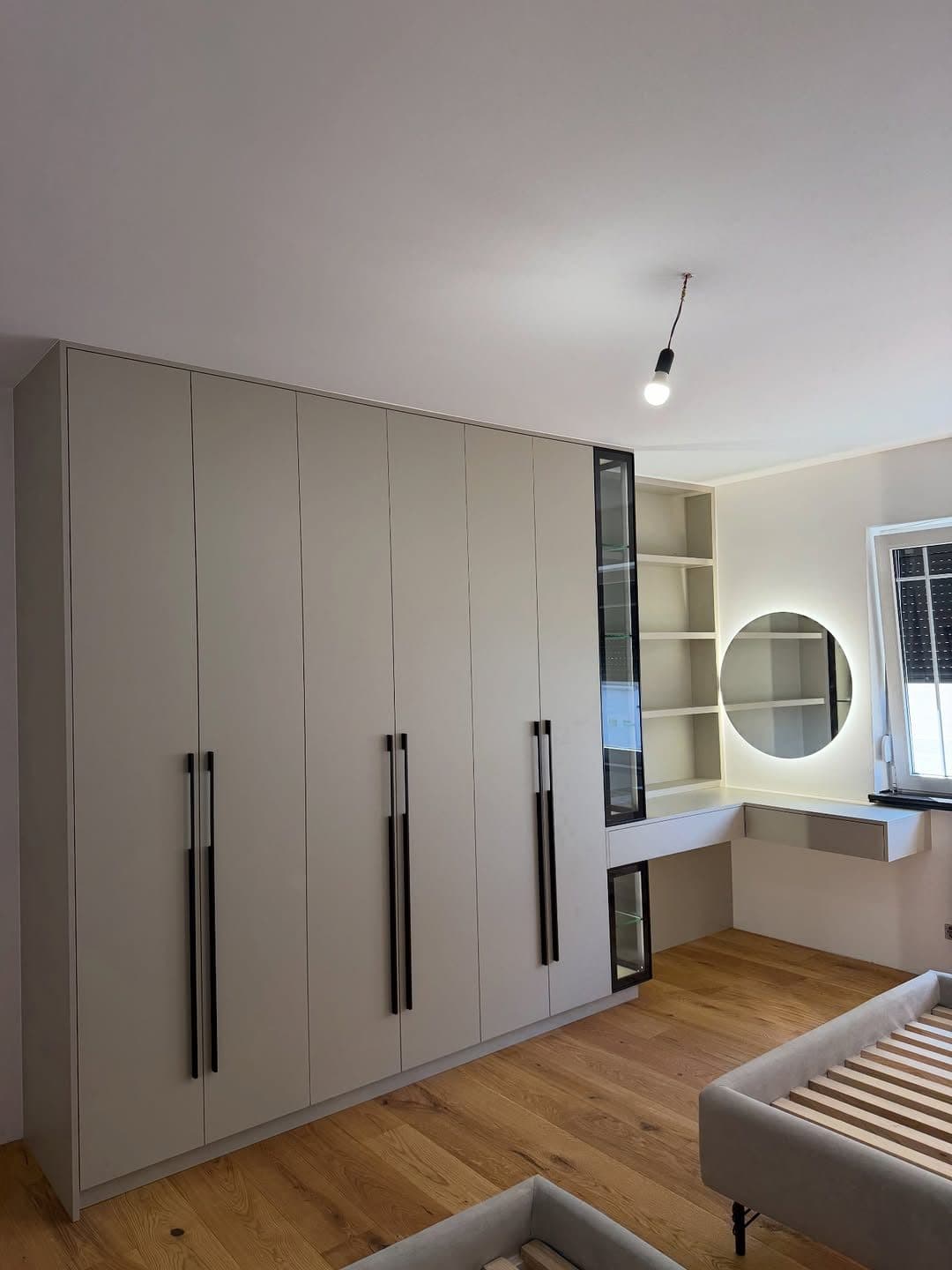 Wardrobe wall with integrated open shelving and round vanity mirror - bespoke joinery by Royalwoods Interiors, Nairobi
